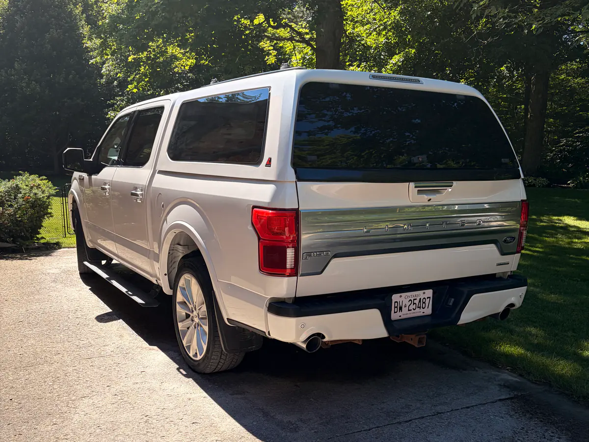 White pickup truck with a colour-matched cap parked on a driveway after a full interior and exterior detail